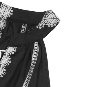 Svart halterneck-blus med vit brodyr och knytband
